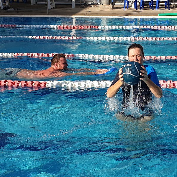 Woman Doing Water Circuit While Man lap Swimming