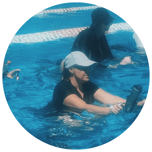 Woman with a bad balance aqua cycling in pool