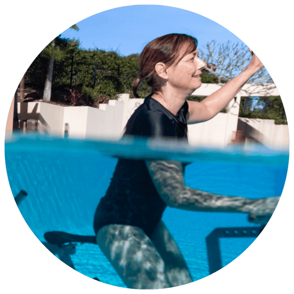 Woman with multiple sclerosis water cycling in pool